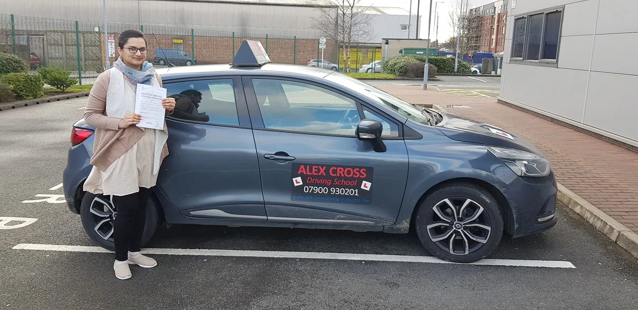 One of Alex's pupils holding her pass certificate beside the car